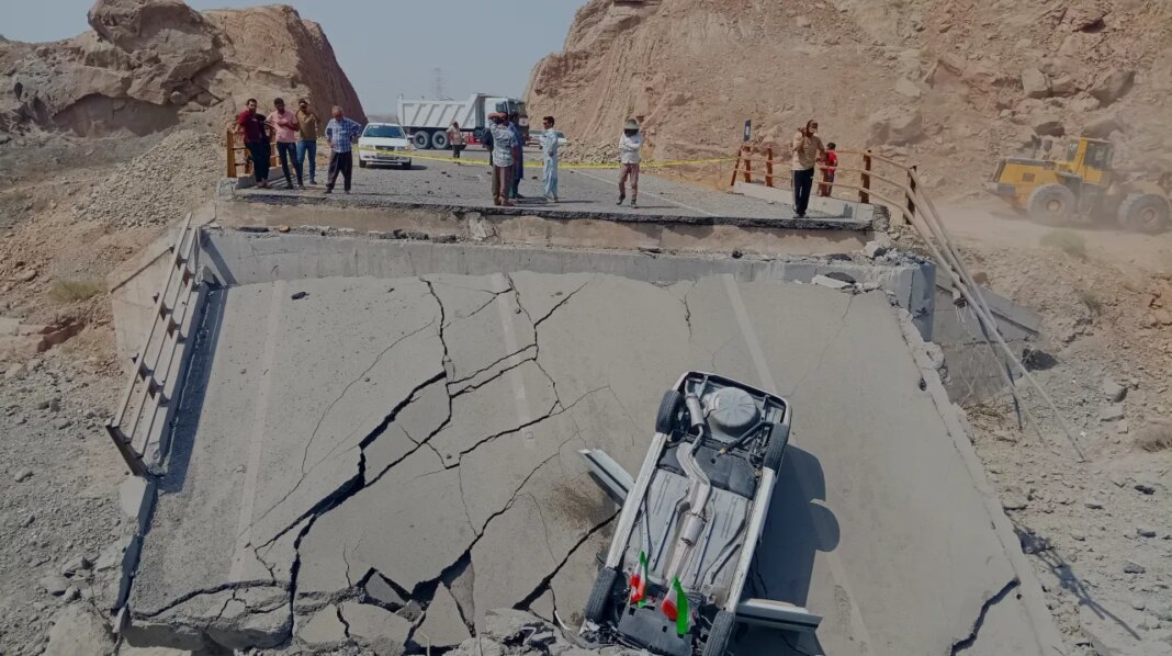 An overturned car sits on a section of a destroyed bridge after a strike in Hormozgan province, southern Iran, Saturday, July 18, 2026. (Mahdi Negahban/Mehr News Agency via AP)