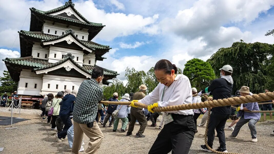 Hundreds of volunteers pull 360-tonne historic Japanese castle back into place by hand