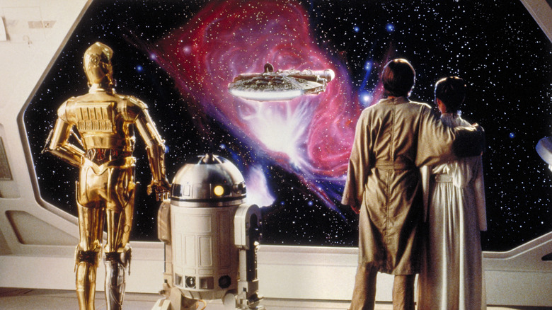 Luke, Leia, R2-D2, and C-3PO watching the Millennium Falcon fly away at the end of 