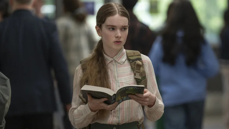 Carrie White looking concerned and holding a book in 