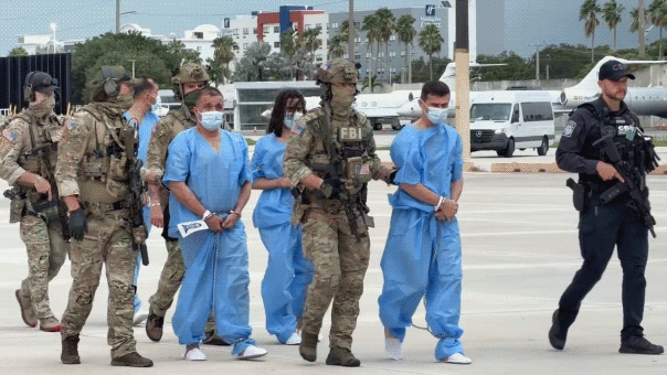FBI agents escort 18 assassination plot suspects